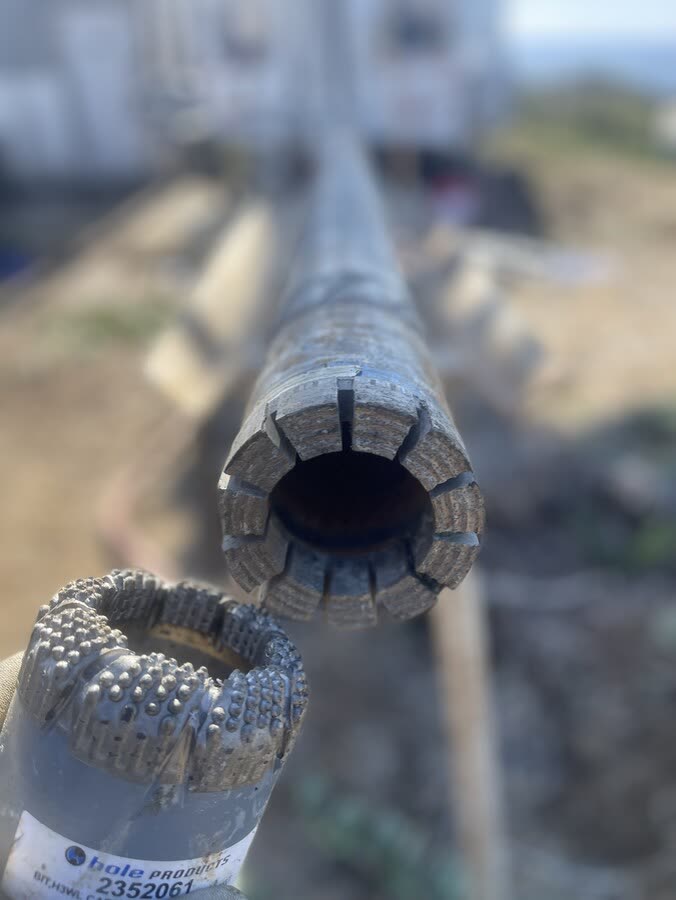 Close-up of a diamond core bit on the end of a core barrel.