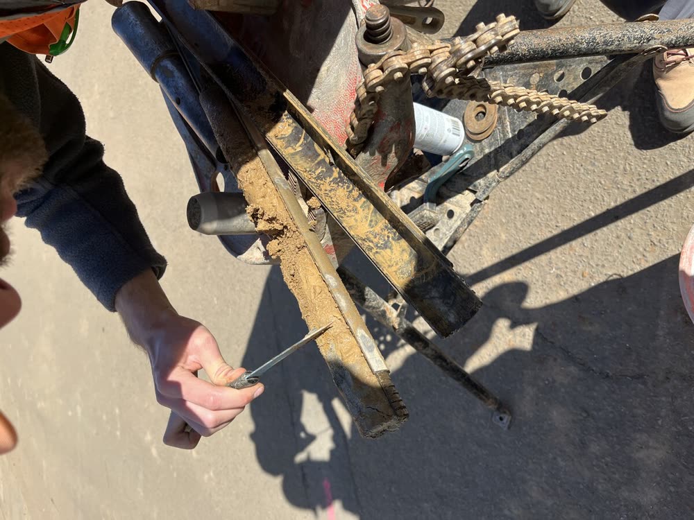 A driller handling a split-tube soil sampler on site.
