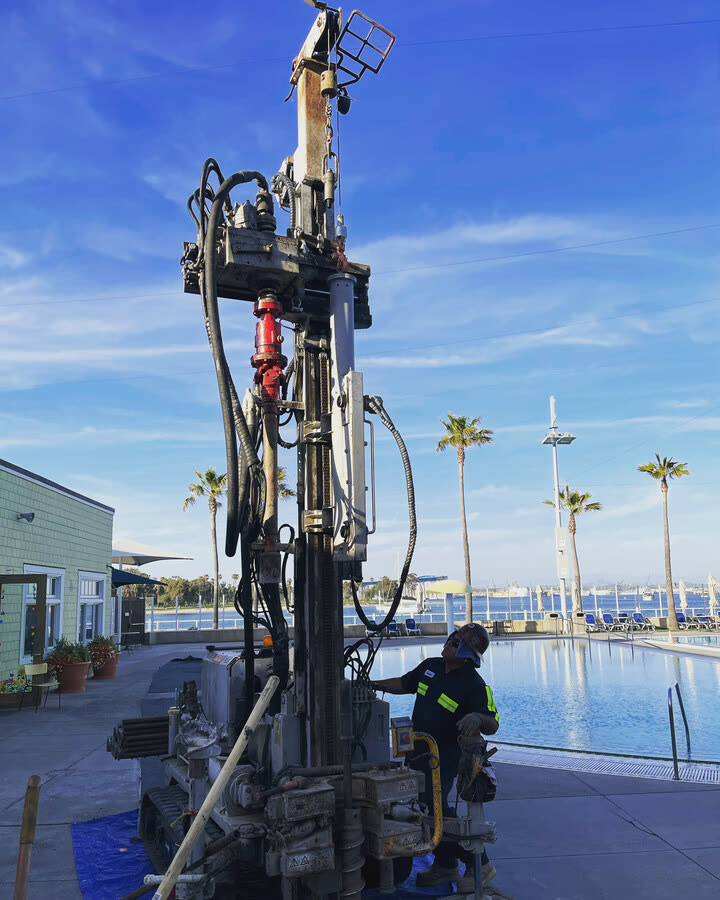A rig working a waterfront site beside a marina.